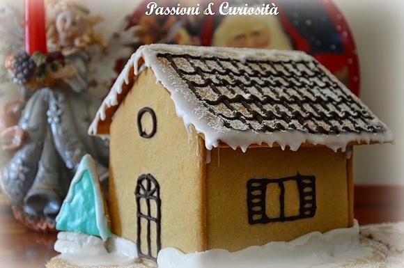 Casetta natalizia di pasta frolla decorata con cioccolato e zucchero a velo